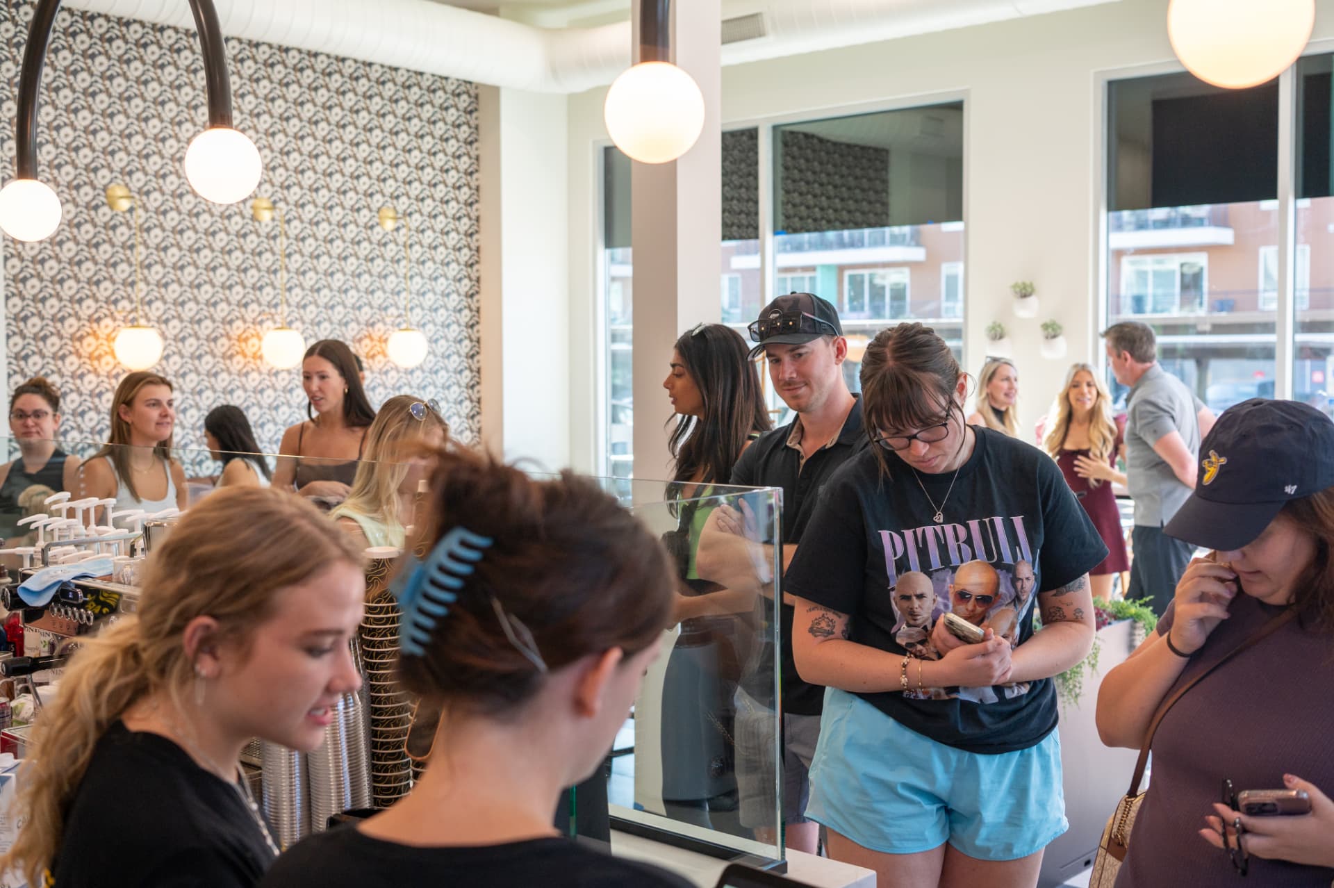 Guests lined up at the Stemistry counter under globe pendants and floral wallpaper