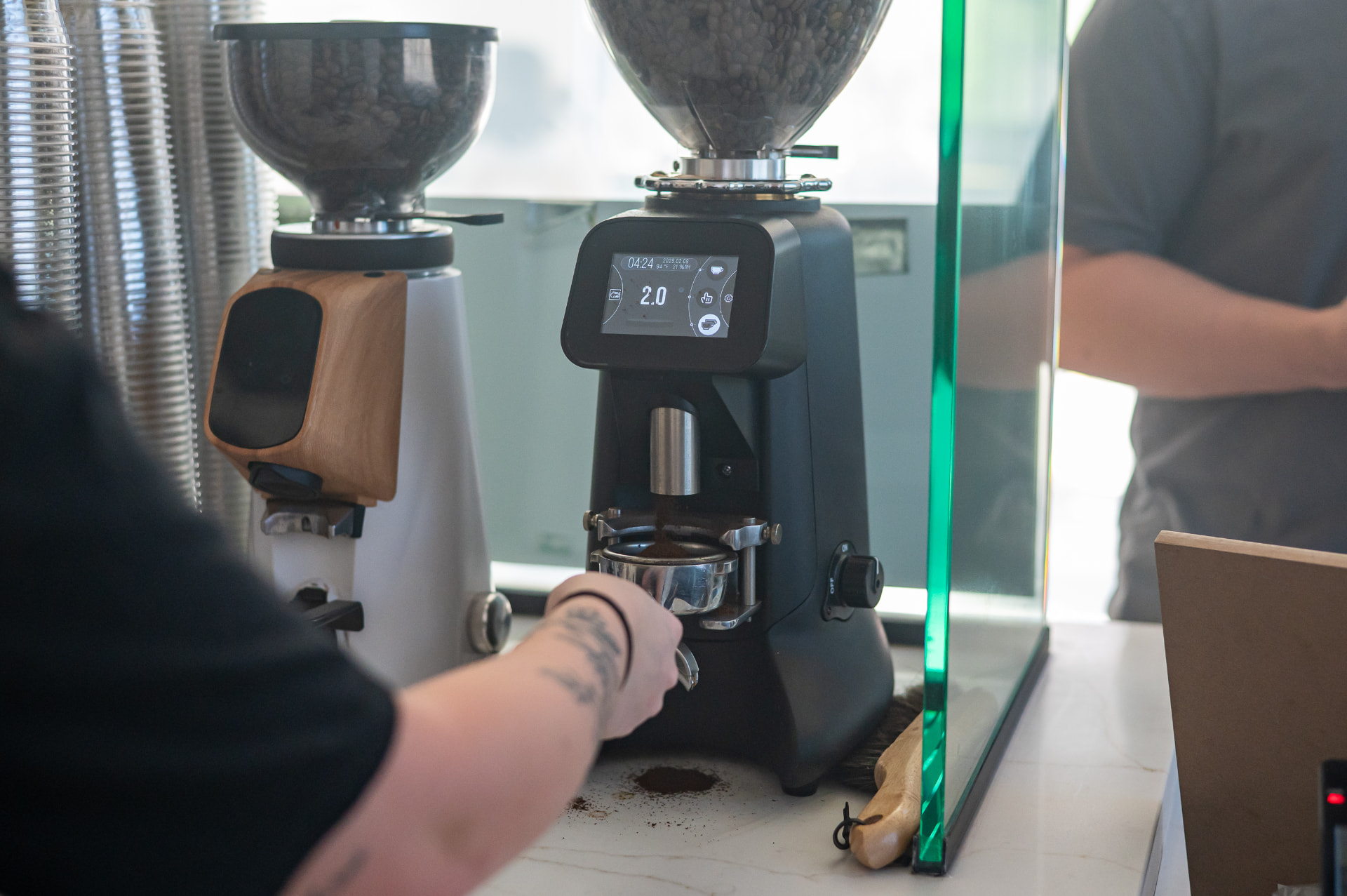 Freshly ground espresso dosing into a portafilter at the coffee bar