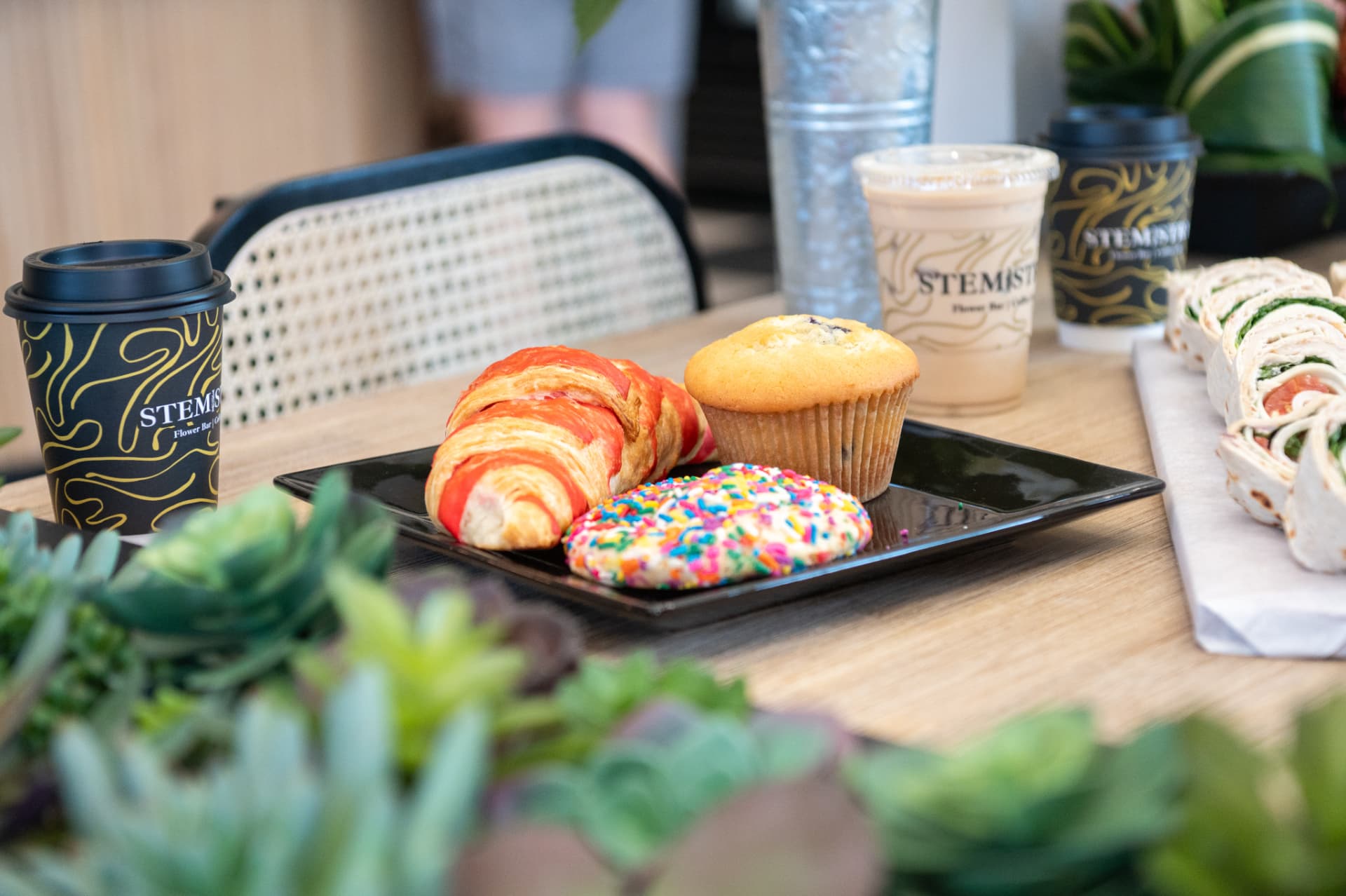 Pastries and Stemistry cups laid out on a café table